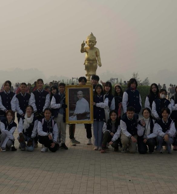 ISV Club volunteers posing together in front of a large golden Buddha statue on a trip to Nepal